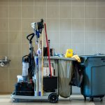 A comprehensive collection of professional cleaning tools on a cart in an indoor environment.